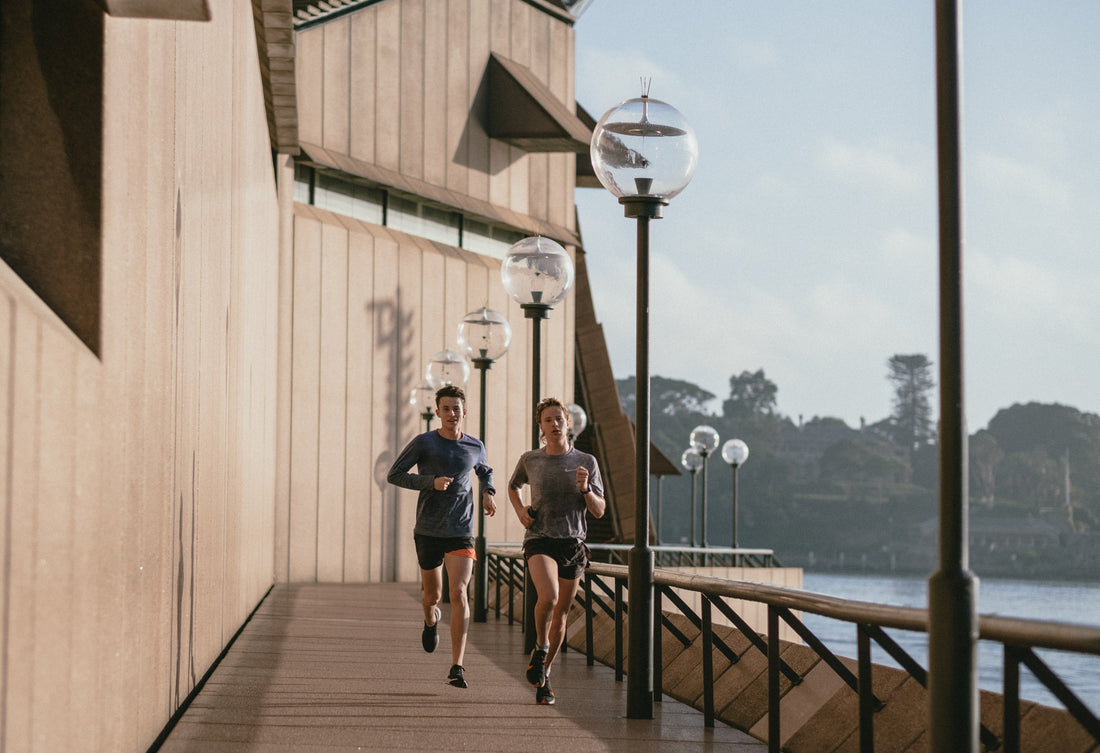 Two people running on a promenade